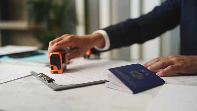 Male customs officer stamping North Korean passport, rejecting visa application