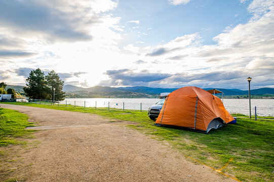a tent on a camping ground next to a lake