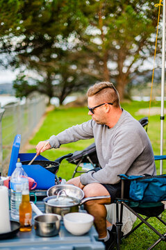 man cooking on a camping set up 