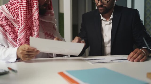 EU or US businessman discussing business project with Arab partner in office