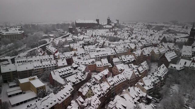 Aerial view on the imperial castle of Nuremberg in Germany covered in snow during winter. Historic half-timbered houses in the foreground. drone view.