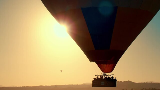 Hot air balloons floating above the iconic fairy chimneys and rock formations of Cappadocia, Turkey, during sunrise.