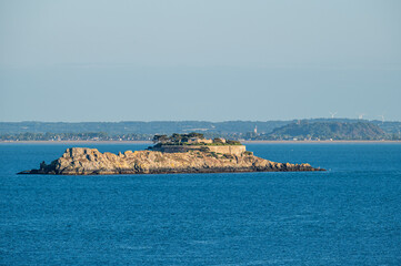 A small rocky island in Brittany hosts a historic fort, surrounded by the Atlantic waters, highlighting coastal defense, rugged terrain, and maritime heritage.

