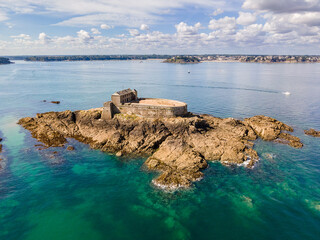 Aerial view of Fort du Petit B&eacute; off the coast of Saint-Malo, Brittany, France, showing its stone fortifications surrounded by tidal waters, highlighting its strategic coastal defense and historic arch