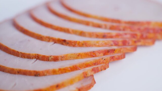 Turkey slices displayed. Thinly sliced orangespiced turkey fanned out. Detailed view of overlapping turkey pieces seasoned with spices and arranged in fan pattern