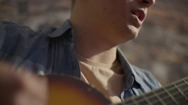 Closeup Of Man Singing And Strumming Guitar, Urban Setting With Man Passionately Playing And Singing Guitar, Caucasian Man Energetically Practicing Singing And Guitar In Cozy Loft Environment