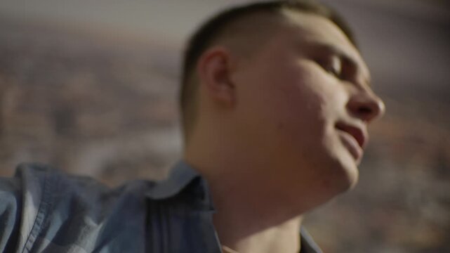 Male Singing Closeup, Caucasian Male Vocalist Singing Softly Against Urban Mural Backdrop, An Expressive Male Singer Passionately Performing With City Scene Behind Him And Artistic Lighting