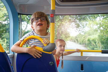 Naklejka premium Kids enjoy a double decker bus ride through beautiful scenery