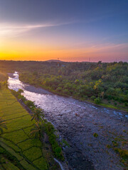 Beautiful morning view in Indonesia, panoramic landscape of rice fields with mountain ranges and clear sky