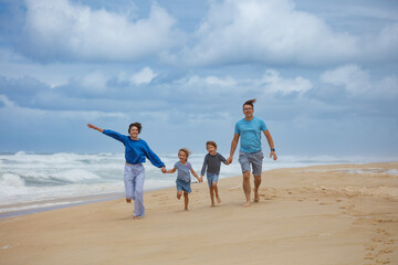 Family Joyfully Running Together on the Sandy Beach