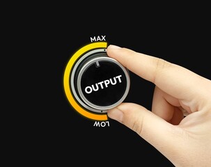 Hand adjusting control knob to maximum power setting black background concept of optimization and efficiency
