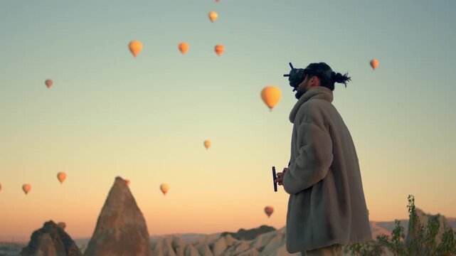 Man wearing virtual reality or FPV goggles while controlling a drone outdoors. Modern technology and innovation concept showing immersive drone piloting, aerial control, and future tech lifestyle.