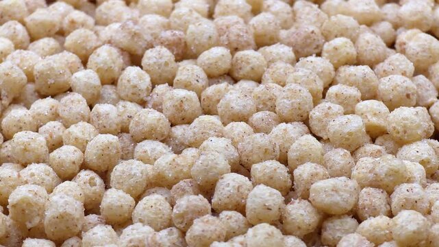 Macro sweet cereal balls texture, crunchy honey corn puffs background
