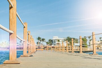 Naklejka premium Wooden pier on sea stretching into distance beyond horizon on sunny summer day. Vacation and Travel Concept.