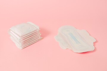 Sanitary napkins packed on pink background. Menstruation cycle, feminine hygiene and protection. Flat layout © Antonio