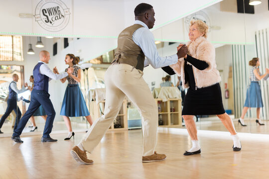 Senior womaSenior woman and man dancing swing in studion and man dancing swing in studio