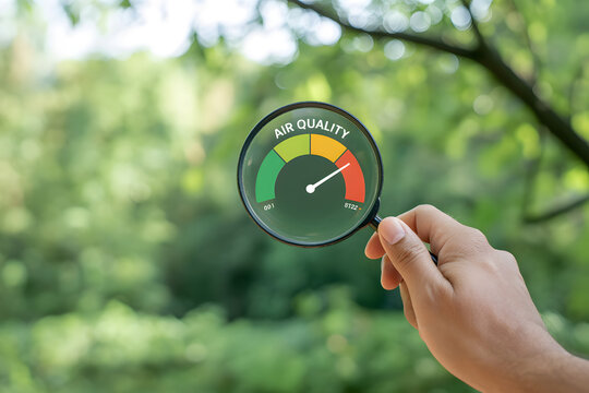 hand holding a magnifying glass to check the good air quality and clean outdoor air quality safe from pollution dust PM 2.5