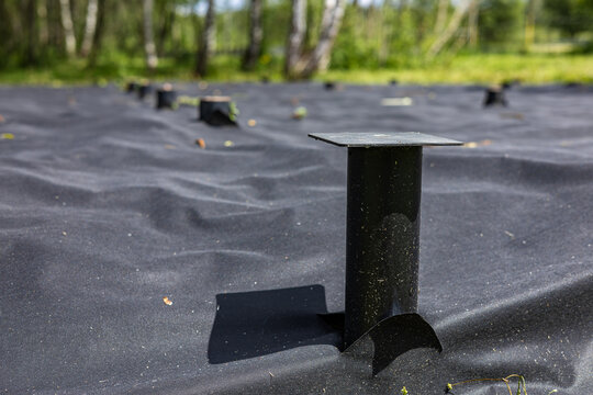 Construction of a pile foundation using metal screw piles and geotextiles. House foundation. Construction work.