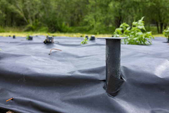 Construction of a pile foundation using metal screw piles and geotextiles. House foundation. Construction work.