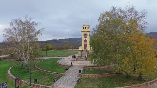A scenic view of the Cegar Battle Monument in Nis, partially revealed behind winter trees, highlighting its historic significance and the peaceful snowy landscape surrounding this Serbian landmark.