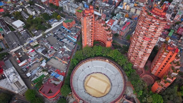 A reversing and rising drone shot reveals the historic La Santamar&iacute;a Bullring in Bogot&aacute;, highlighting this iconic tourist landmark while subtly showing its place within the surrounding city.