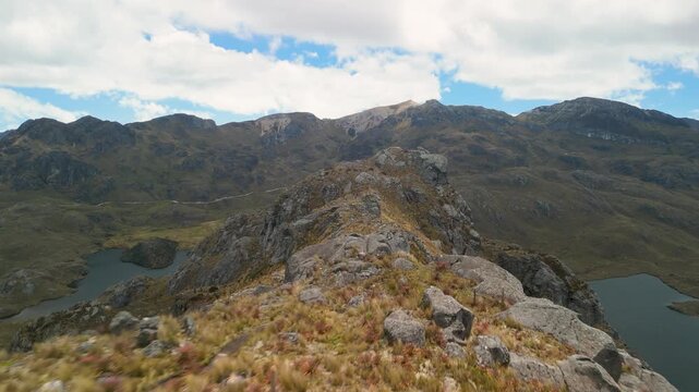 Fast-paced cinematic drone footage flying low and close to a rugged mountain ridge revealing steep rocky cliffs and high-altitude paramo tundra in the Ecuadorian Andes