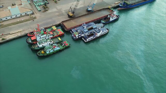 Aerial view of the busy port activity with various ships docked at the bustling port.
