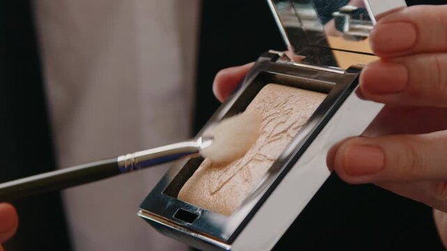 Macro Shot of Professional Makeup Brush Picking Up Shimmering Face Highlighter from Luxury Compact Mirror Case, Cosmetics Product Preparation in Studio 4k