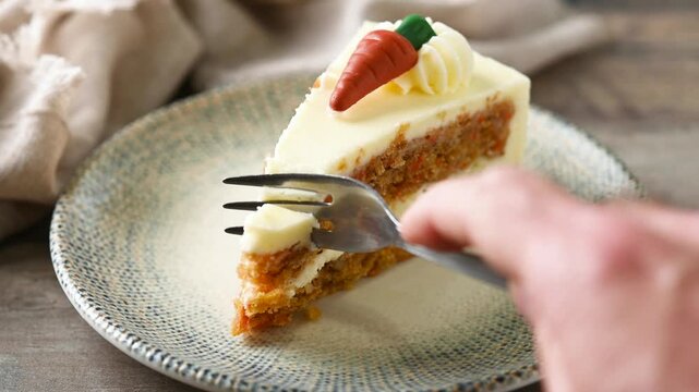 Eating carrot cake slice with cream cheese frosting