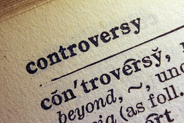 Word controversy printed on dictionary page, macro close up