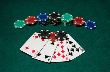 Playing cards and poker chips are spread out on a green table. Two pairs indicates a good win, full of excitement and strategy.