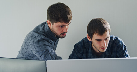 Team adult male engineer collaborate on robotic hand project using AI code solutions machine learning at tech workspace. Artificial intelligence interface, collaboration support prototype development.