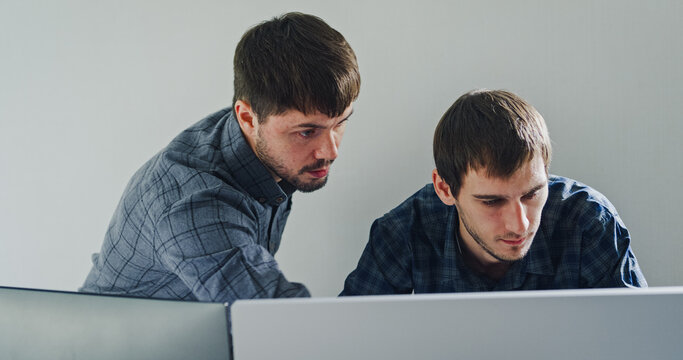 Team adult male engineer collaborate on robotic hand project using AI code solutions machine learning at tech workspace. Artificial intelligence interface, collaboration support prototype development.