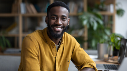 Obraz premium Cheerful positive African American freelancer laughing genuinely at camera in workspace happy successful remote worker portrait showing joy satisfied independent professional
