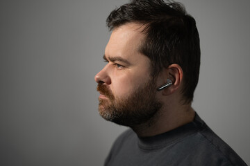 Obraz premium Bearded man with wireless earphone in ear