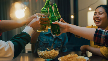 Closeup of Group of multiethnic adult Asia friend drinking alcohol beer bottle glass and having fun laugh enjoy hangout party in night life indoor home. Happy hour millennial generation inside house.