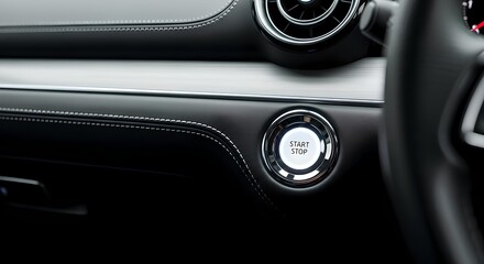 Naklejka premium Illuminated start stop engine button on sleek black leather car dashboard with silver accents.