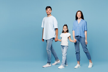 Full body side view young happy parents mom dad with child kid daughter girl wearing casual clothes...
