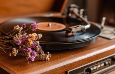 Obraz premium Vintage turntable playing vinyl with dried flowers close up