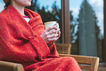 Female holding cup of hot drink in cozy atmosphere