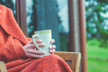 Female holding cup of hot drink in cozy atmosphere