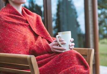 Female holding cup of hot drink in cozy atmosphere