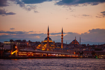 Obraz premium Evening in Istanbul. The illuminated New Valide Sultan Mosque and the Galata Bridge.