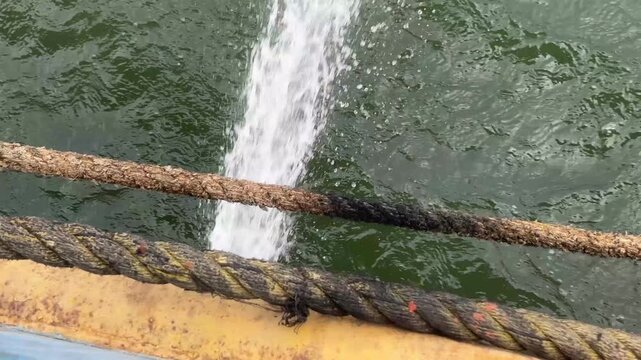 Close up of jet of water being expelled at high speed during ferry crossing on river. Real time