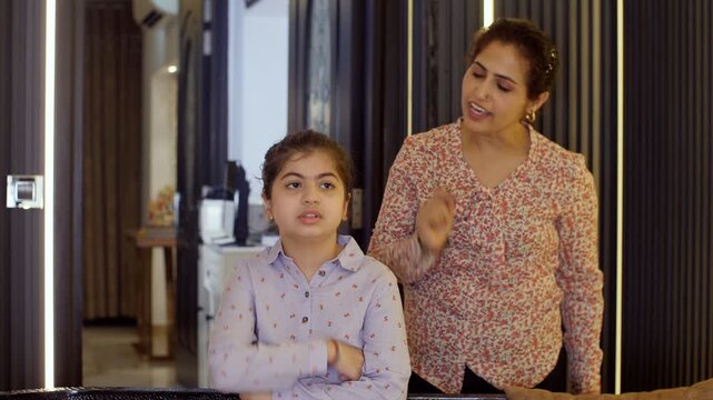 An angry and an annoyed Indian woman screaming / shouting at her little girl - parenting issues  confrontation. A frustrated Indian mother scolding her little daughter - family issues  a misunderst...