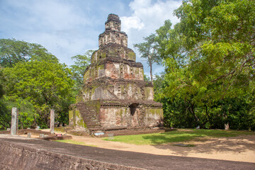 Fototapeta premium The ancient city ruins of Polonnaruwa surrounded by lush tropical vegetation, featuring traditional stone structures and historic remains. An idyllic and peaceful heritage site reflecting Sri Lanka’s 