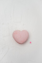 Pink heart-shaped macaron presenting a sweet treat and dessert, embodying concepts of love, romance, and celebration, suitable for Valentine's Day on a minimalist white background