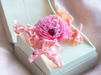 Jewelry. Metal chain (necklace) with stylish pink heart pendants in gift box. Rose and petals of rose creating, tender, romantic atmosphere. Valentine's day,  mother's, woman's day, love holidays.