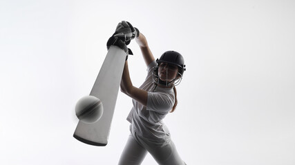 Obraz premium Cricket player hitting ball with bat during powerful shot in studio. Concept of professional cricket action, athletic performance, competitive sports moment, training intensity and commercial visuals.