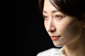 Fototapeta premium 黒い背景でクールな表情の日本人女性
